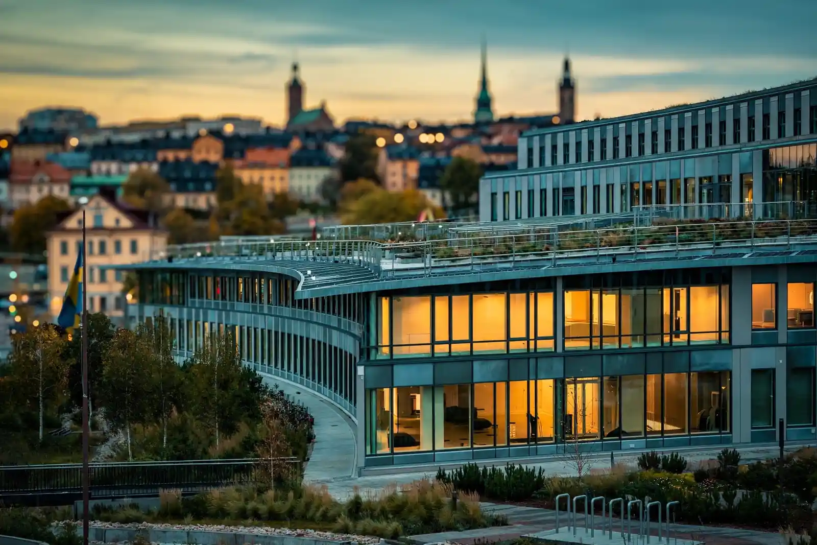 Spelinspektionens moderna kontorsbyggnad i Stockholm vid solnedgång med svensk flagga.
